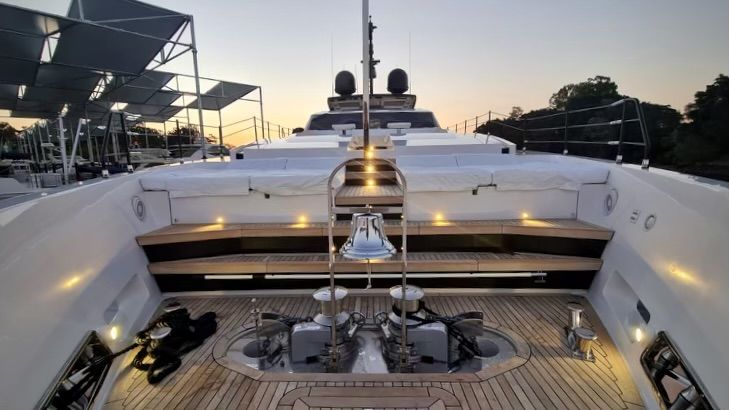 The aft deck of a motor yacht at a marina at sunset