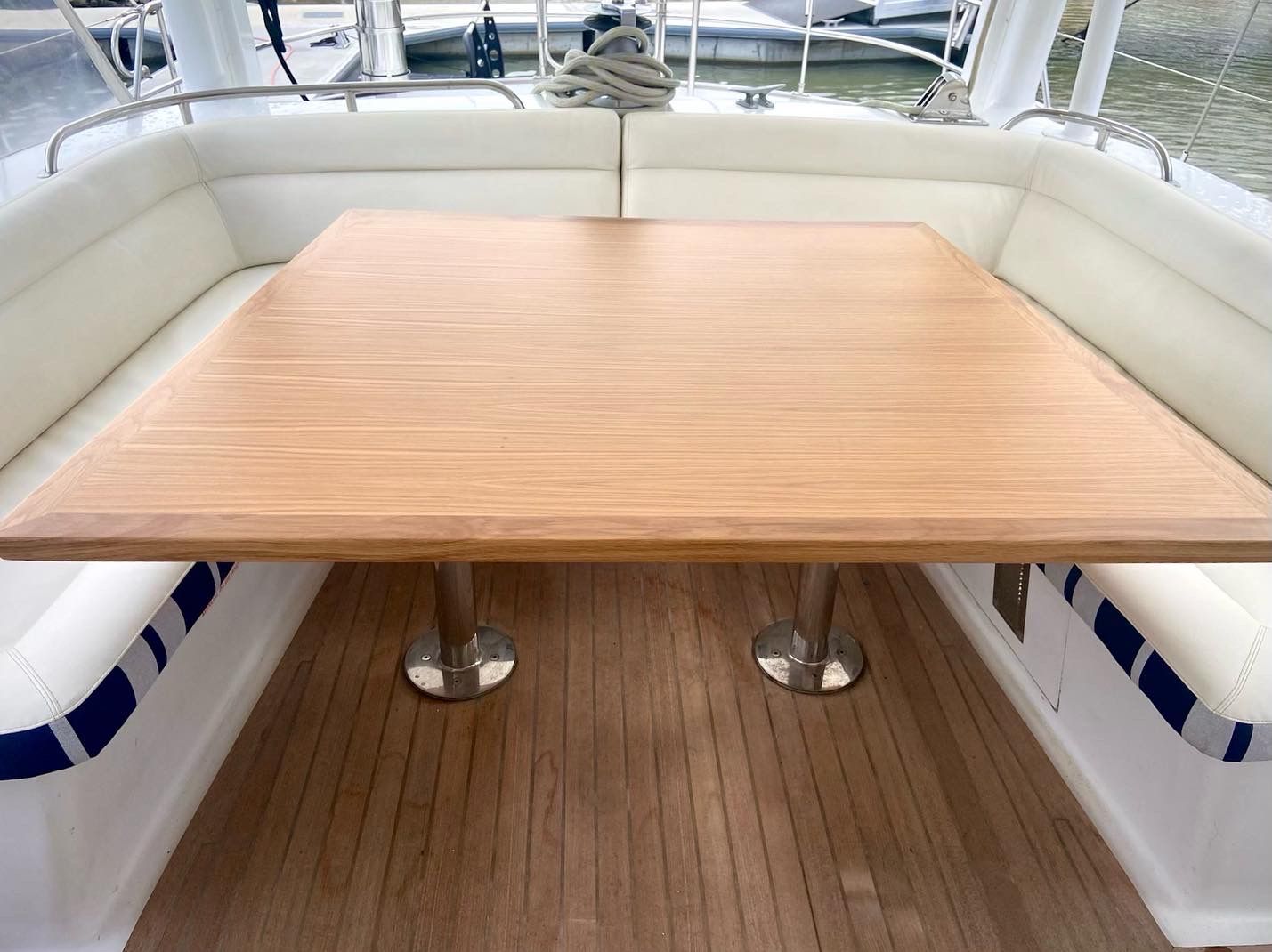 A cleaned teak cockpit table and teak deck on a motor yacht